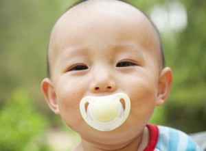cute baby with pacifier in mouth